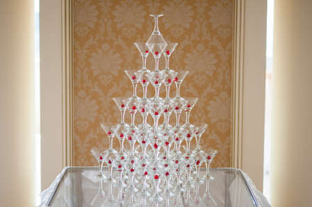 Pyramid of glasses of champagne with cherryの写真素材