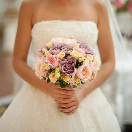 Beautiful wedding bouquet in hands of the bride. no faceの写真素材