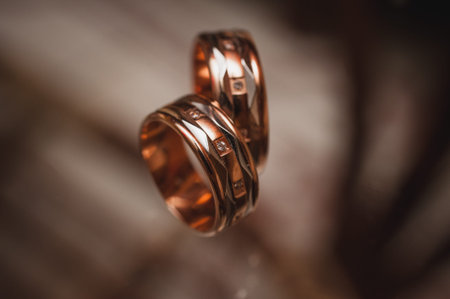 Pair of yellow gold wedding rings  on dark backgroundの写真素材