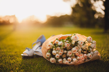 rose bouquet on green grass and women shoesの写真素材