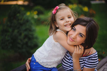 Happy young mother with little daughter outdoor in parkの写真素材