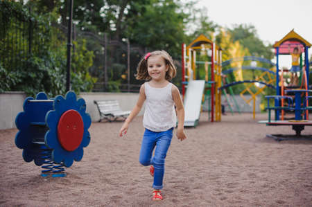 Beautiful little girl on outdoor playground at summertimeの写真素材