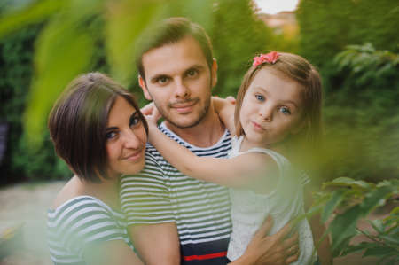 Happy active family having fun outdoors in the spring park against natural green backgroundの写真素材