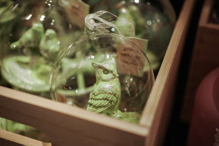 transparent Glass chrismas toys with green birds inside in wooden box close upの写真素材