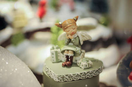 Little decorative colored angel on shelf with decorの写真素材
