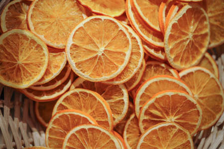 Slices of fresh dried orange lying on old rustic wooden background close upの写真素材