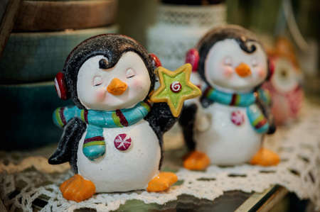 Two toy penguin wearing headphones on shelfの写真素材