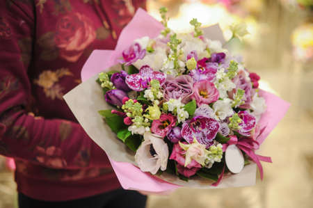 Pastel colors bouquet made of orchids, Freesia, Carnation and Limonium flowers in handsの写真素材