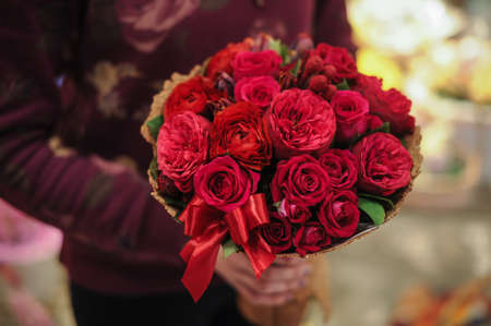 beautiful bouquet of different  red flowers in handsの写真素材
