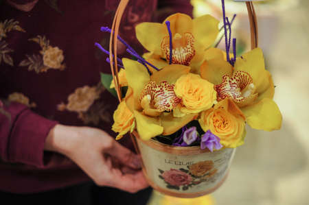 Basket with yellow orchid flowers. in handsの写真素材