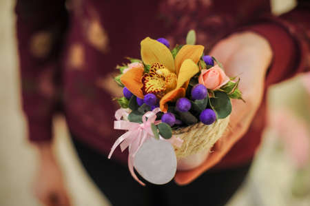 Basket with yellow orchid flowers. in handsの写真素材