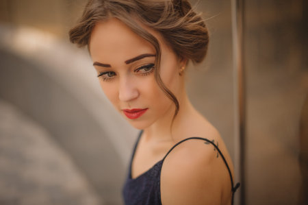 portrait of young girl with red  lips and hair up  not looking at the camera outside