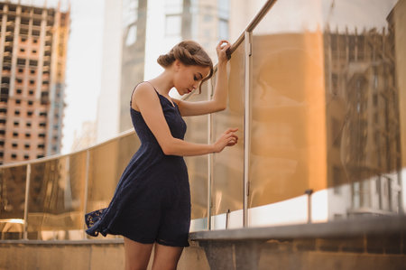 Beautiful woman in black dress with hair up outdoors not looking in cameraの写真素材