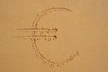 The sign of the EURO currency  drawn in the sand at the beach