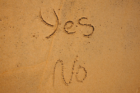 The words YES and NO written in sandの写真素材