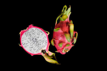 sliced and whole pitahaya or dragon fruit on black background.の写真素材