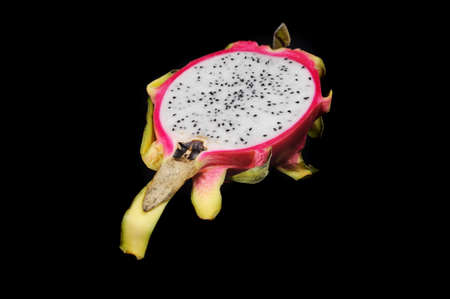 Fresh dragon fruit cut in half isolated on a black background closeupの写真素材