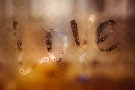 Love written sign on foggy window background. Attractive romantic messageの写真素材