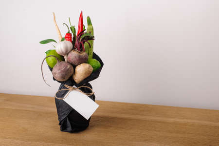 The original unusual edible bouquet of vegetables and fruits on  wood with cardの写真素材