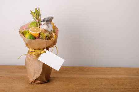 The original unusual edible bouquet of vegetables and fruits on  wood with cardの写真素材
