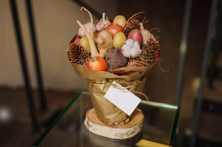 The original unusual edible bouquet of vegetables and fruits on  wood with cardの写真素材