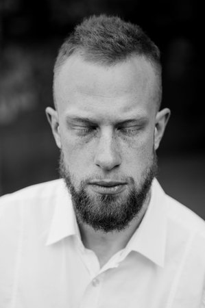 portrait of young red hair man with closed eyes with beard black and white  vertical
