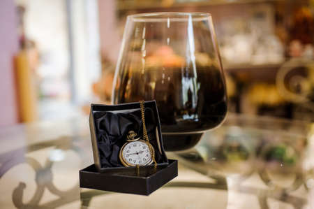 Black box with golden pocket watch on chainの写真素材