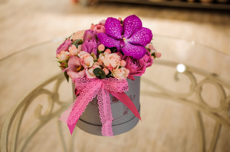 Small bouquet of pink and purple flowers  on table in box