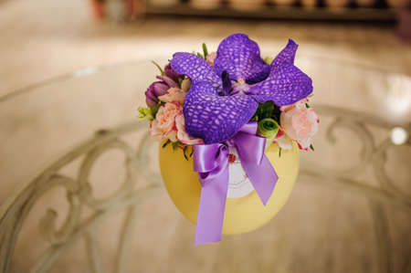 Small bouquet of flowers  with purple orchid in vaseの写真素材