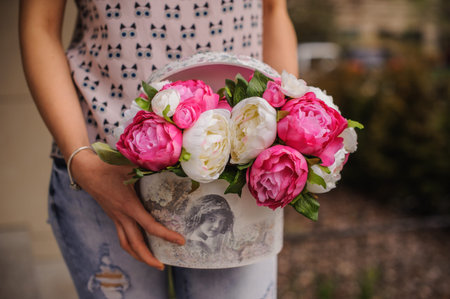 Rich bunch of white and pink peonies box in handsの写真素材
