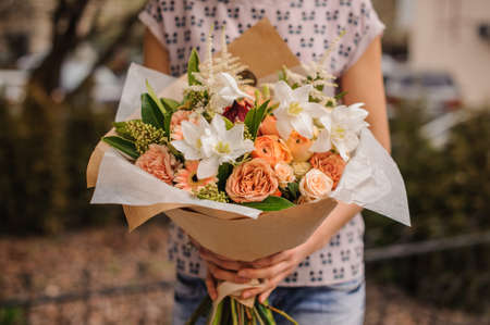 Bouquet of the different mixed  orange flowers in woman handsの写真素材