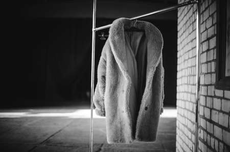 Fake fur coat on clothes rack black and whiteの写真素材