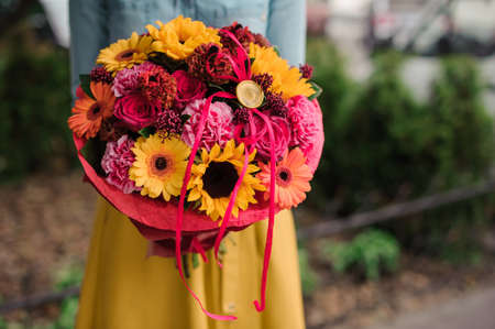 girl holding colorful bouquet with different Gerbera flower compositionの写真素材