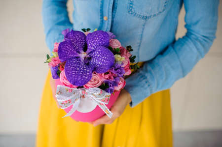 girl holding beautiful pink bouquet of mixed flowers in pink vaseの写真素材