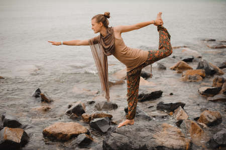 young woman doing yoga of sea on beachの写真素材
