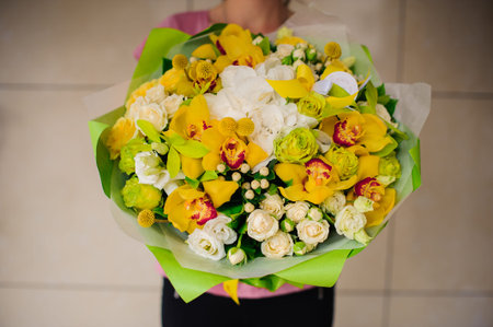 Beautiful bouquet of yellow flowers in hands of the girl no faceの写真素材