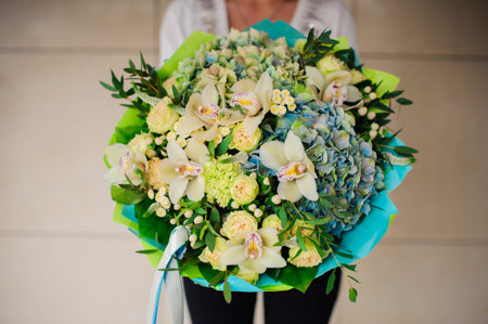 Woman holds a green bouquet no face
