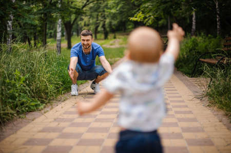 Child boy Running Towards Father in parkの写真素材