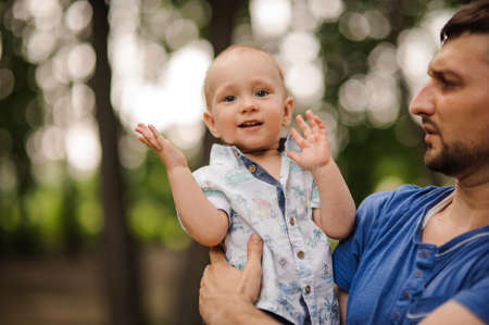 Portrait happy father and son on hands summer day in parkの写真素材