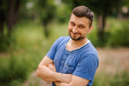 A portrait of a young white handsome man posing outdoors.