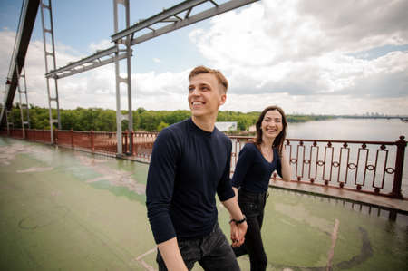 Young smiling couple walking on the bridgeの写真素材