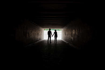 Silhouette of young happy couple holding handsの写真素材