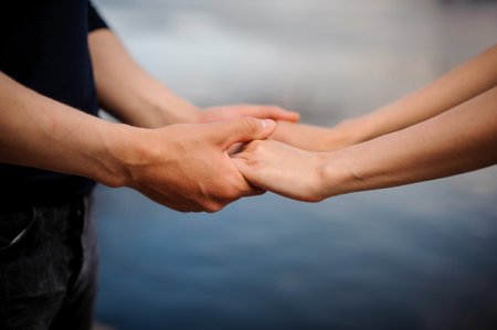 Happy couple holding hands together. water backgroundの写真素材