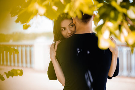 A picture of a young romantic couple hugging in the park in autumnの写真素材