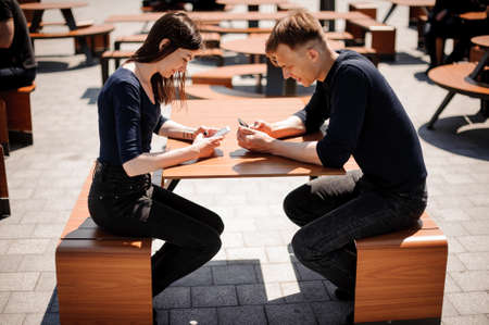Couple looking at their smart-phones in the restaurant .の写真素材