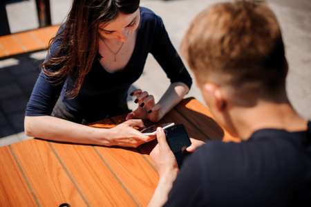 Couple looking at their smart-phones in the restaurant .