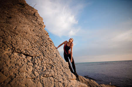 female rock climber climbs on a rocky wallの写真素材