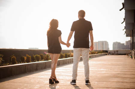couple from behind holding hands looking on city viewの写真素材