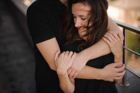 Young loving couple outdoors hugging and looking away, future and relationships conceptの写真素材