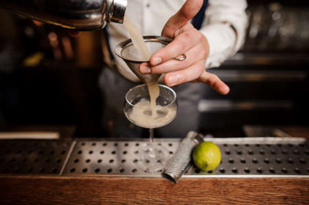 close up barmans hands with cocktailの写真素材